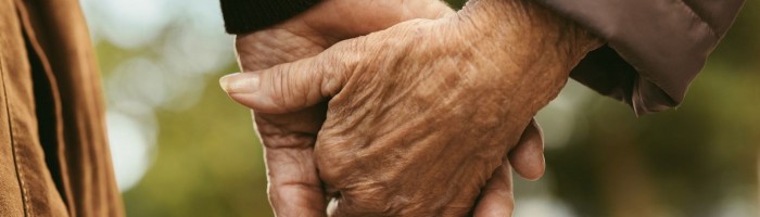 Elderly couple holding hands