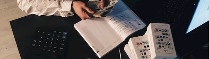 man writing in notebook at desk