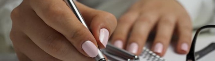 woman writing in notebook (close up)