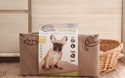 3-pack of Conni Pet Pads next to dog bed