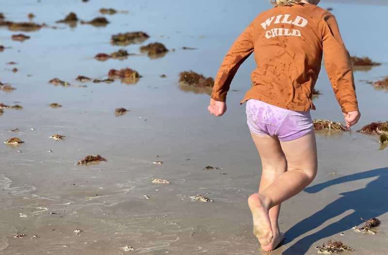 child running through beach
