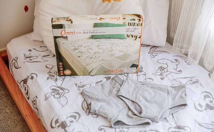 conni kids reusable bed pad with tuck ins packaging on conni kids reusable bed pad